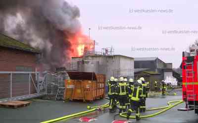 Meterhohe Flammen lodern aus Lagerhalle: Bahnstrecke gesperrt: Werkstatt und Silos einsturzgefährdet - Zugverkehr zwischen Hamburg und Kiel eingestellt - Anwohner werden aufgefordert, Fenster und Türen zu schließen